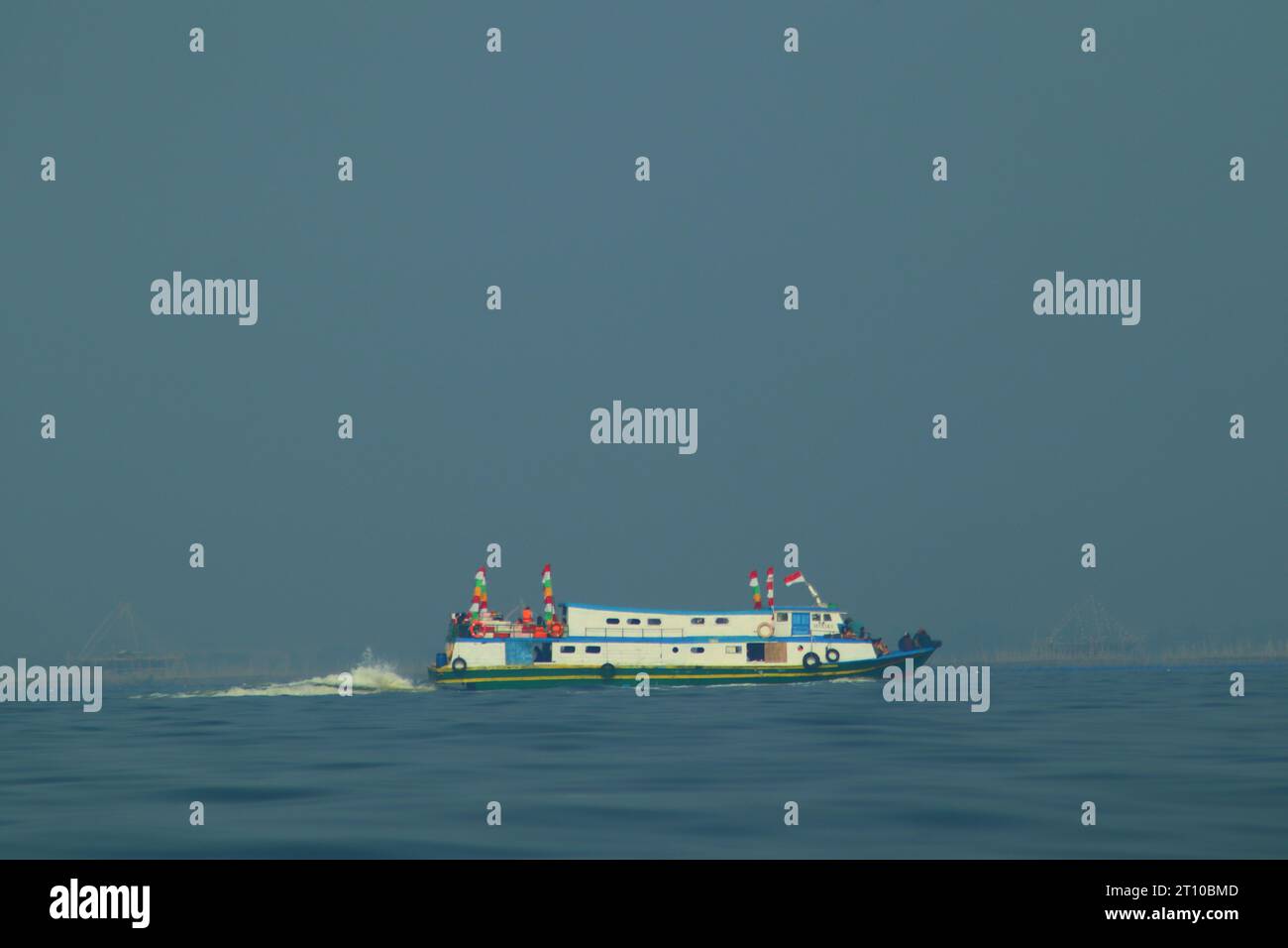 navires à passagers et bateaux de pêche, également visibles au-dessus du vaste océan. sur fond de mer bleue et de nuages bleus. Banque D'Images