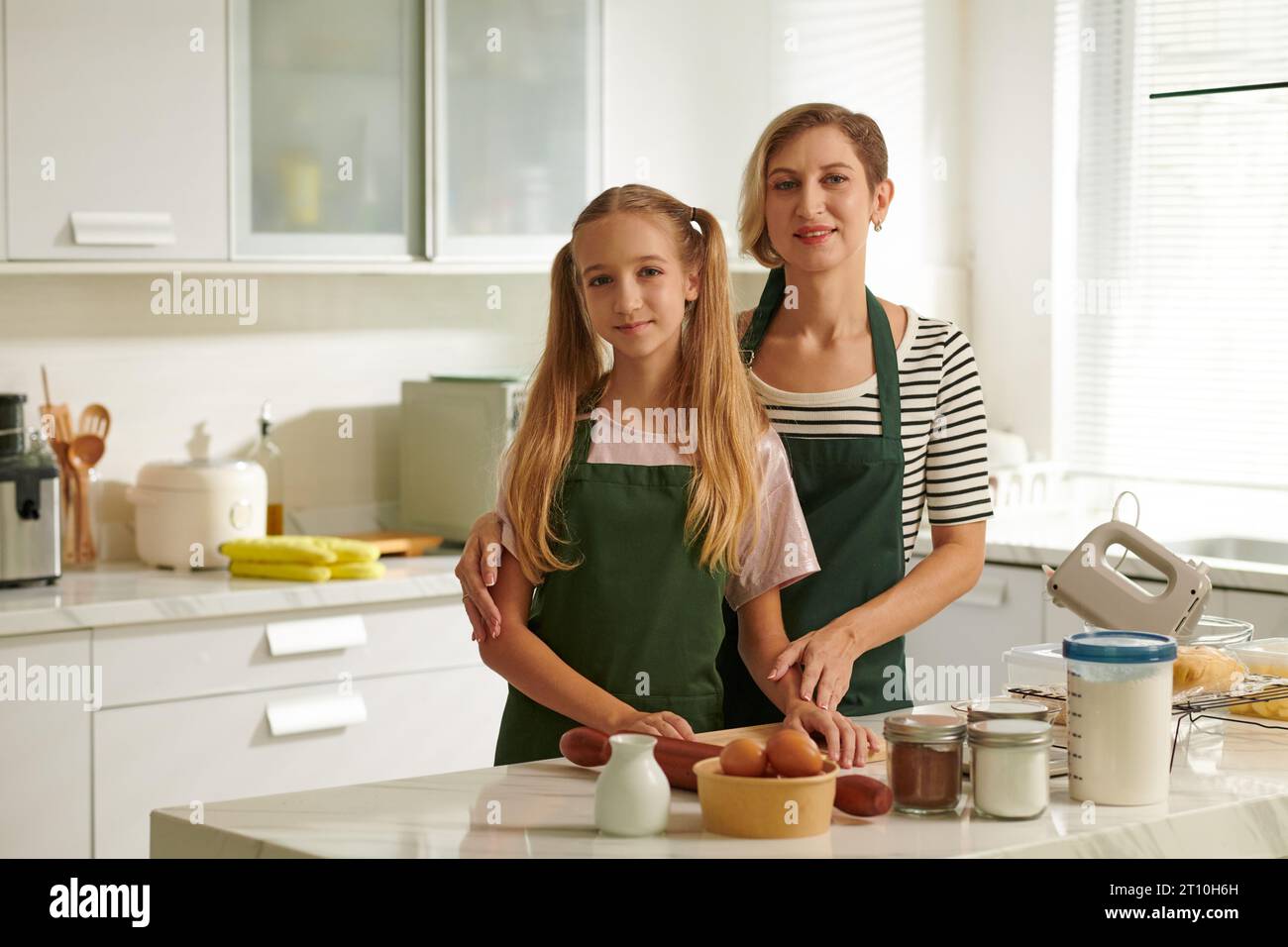 Femme souriante et sa fille adolescente cuisinant le dîner ensemble Banque D'Images