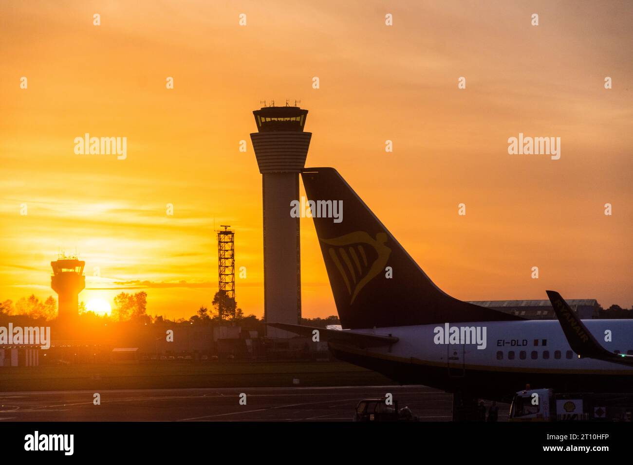 Aéroport de Dublin, Irlande, coucher de soleil et tours de contrôle et avions sur stand. Banque D'Images