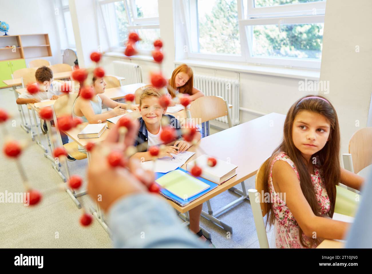 Garçons et filles élèves étudiant par la structure moléculaire pendant la conférence en classe Banque D'Images