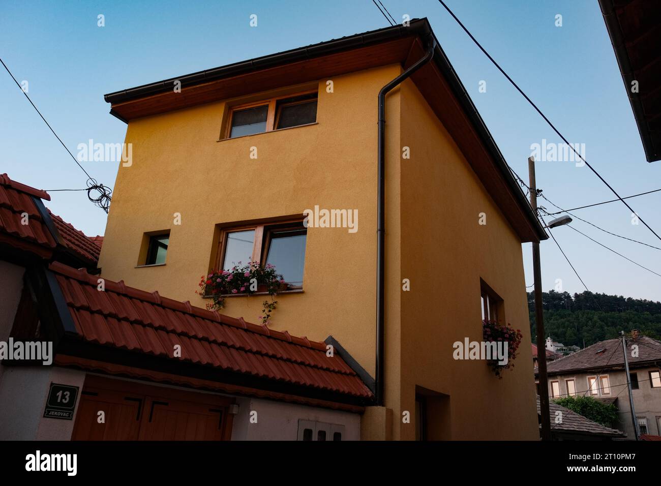 Une maison bosniaque radieuse, ornée de teintes dorées de jaune et d'orange, se dresse fièrement, reflétant le riche patrimoine culturel de la Bosnie. Banque D'Images