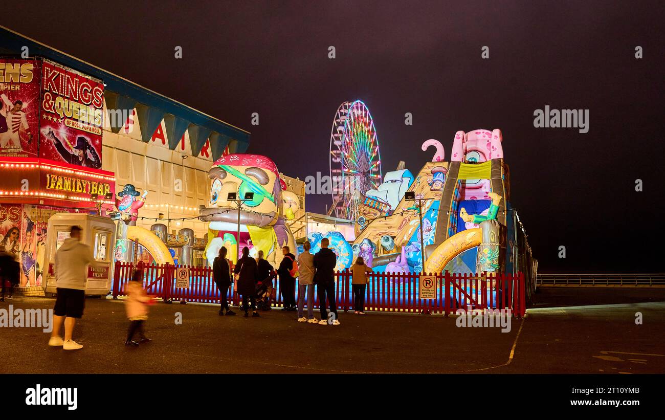 Château gonflable pour enfants et grande roue Central Pier la nuit Banque D'Images