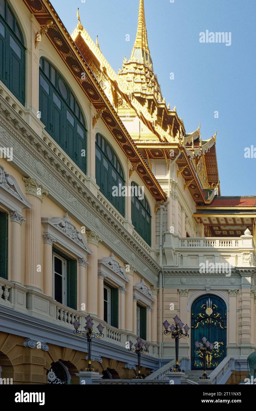 Une magnifique structure avec une façade blanche immaculée et des embellissements or extravagants brille à la lumière du soleil sous un ciel bleu impeccable. Banque D'Images