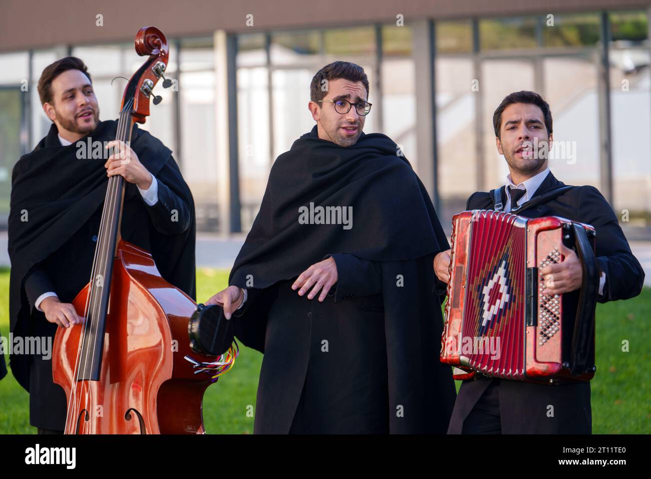 Les étudiants en tenue académique traditionnelle et cape noire chantent et jouent des instruments de musique en tant que membres de l'Estudantina Universitária de Coimbra Banque D'Images