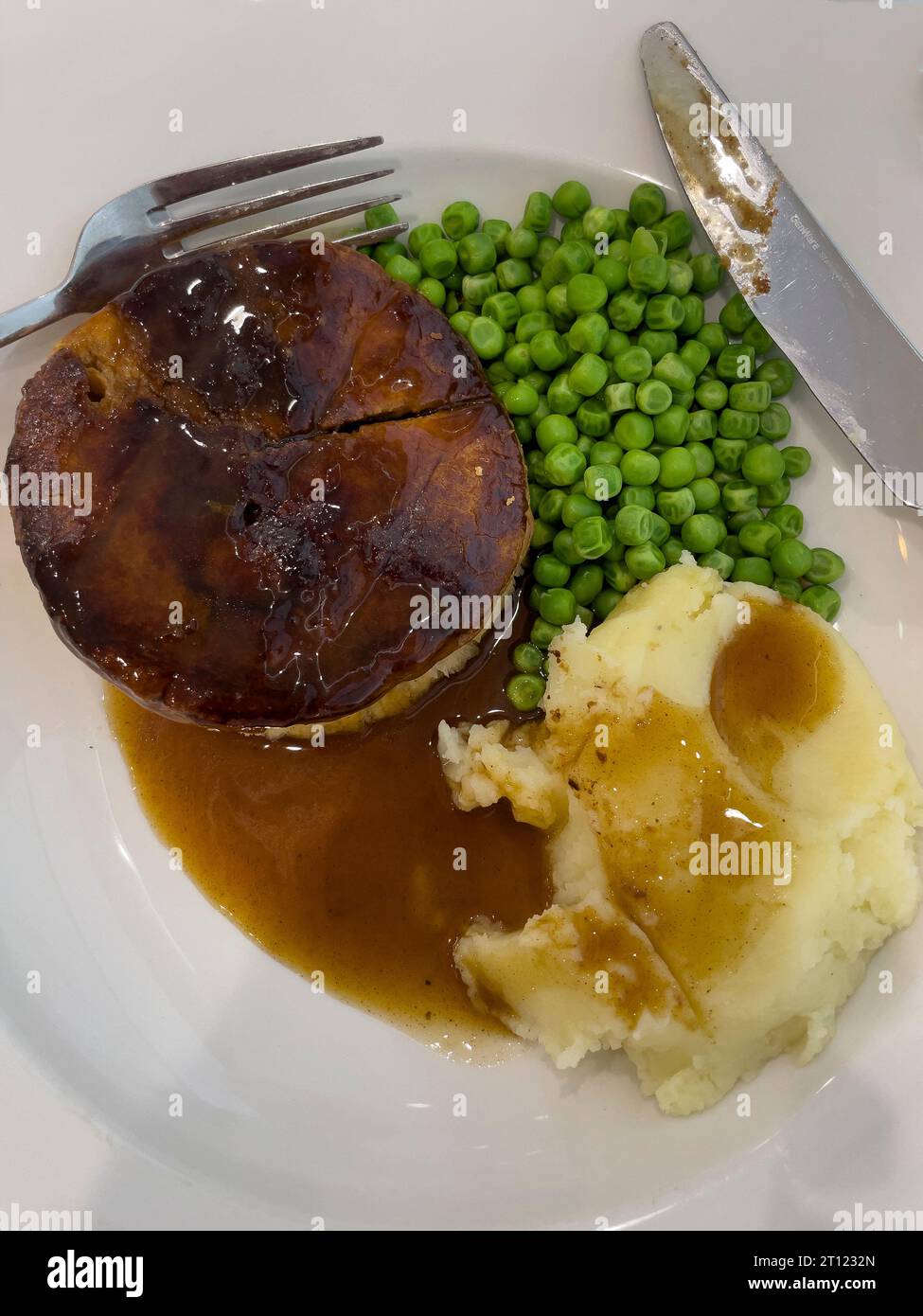 Royaume-Uni. 6 octobre 2023. Un repas de midi de tarte à la viande avec des pois frais, de la sauce et de la purée de pommes de terre. Banque D'Images