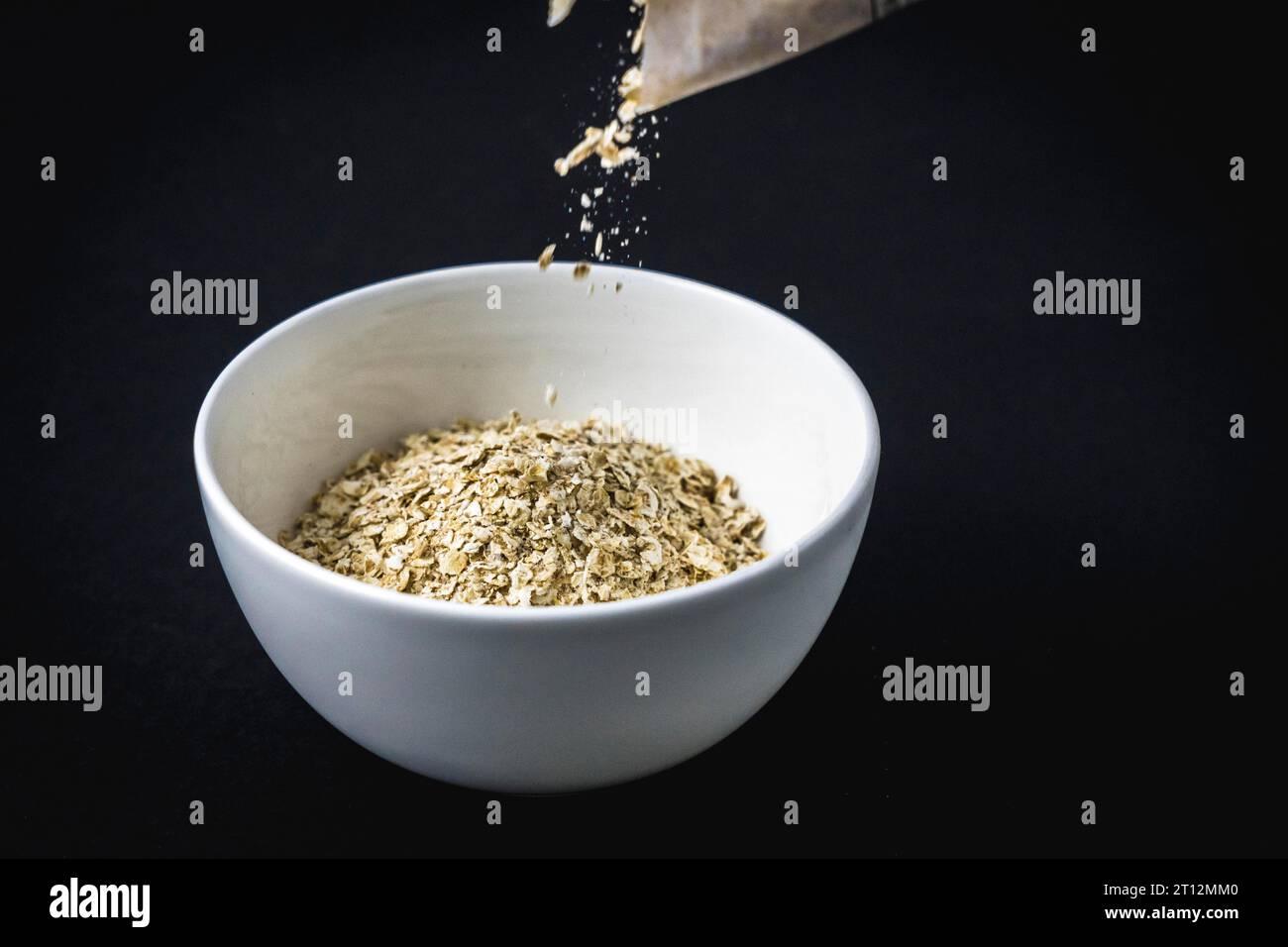 Recette de flocons d'avoine avec noix, pruneaux, cannelle et sucre. Mettez d'abord la farine d'avoine dans une tasse Banque D'Images