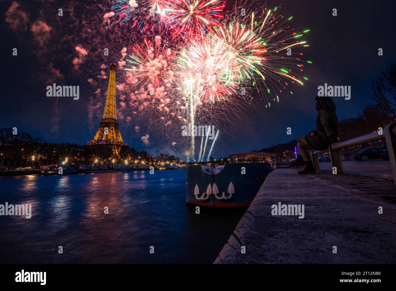 Une jeune femme dans la ville de l'amour profitant d'un feu d'artifice près de la Seine à Paris. France Banque D'Images