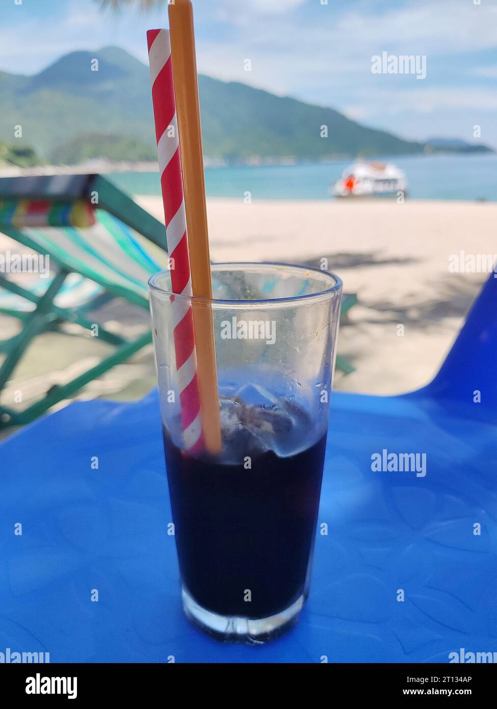 café frais froid avec de la paille à boire sur la plage en journée ensoleillée Banque D'Images