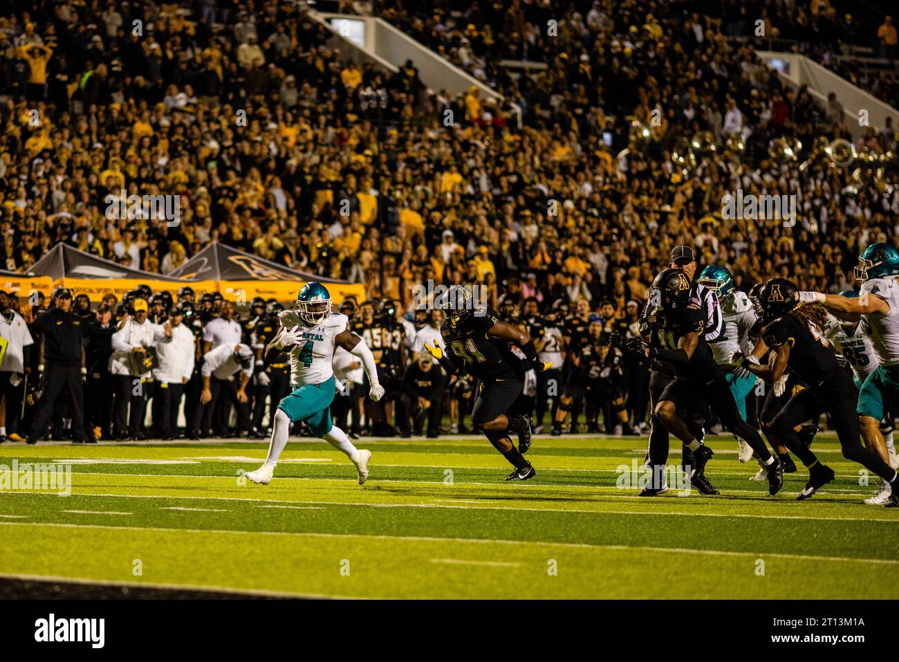 Boone, Caroline du Nord, États-Unis. 10 octobre 2023. Coastal Carolina Chanticleers Running back CJ Beasley (4 ans) se détache de Appalachian State Mountaineers Defensive Tackle Markus Clark (91 ans) lors du quatrième quart-temps du match de football Sunbelt au Kidd Brewer Stadium de Boone, NC. (Scott Kinser/CSM). Crédit : csm/Alamy Live News Banque D'Images