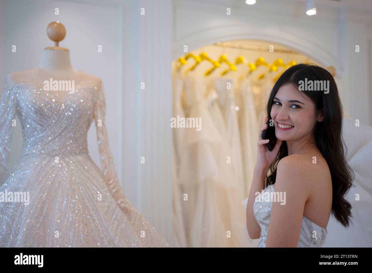 La mariée essaie sa robe au studio. Cérémonie de mariage et concept de style de vie. Banque D'Images