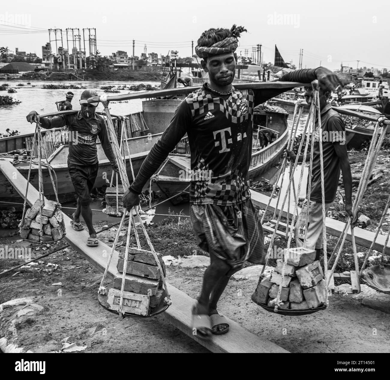 Les gens déchargent des briques du bateau, image capturée le 29 mai 2022, depuis Amen Bazar, au Bangladesh, où les travailleurs sont occupés à décharger des briques lourdes Banque D'Images