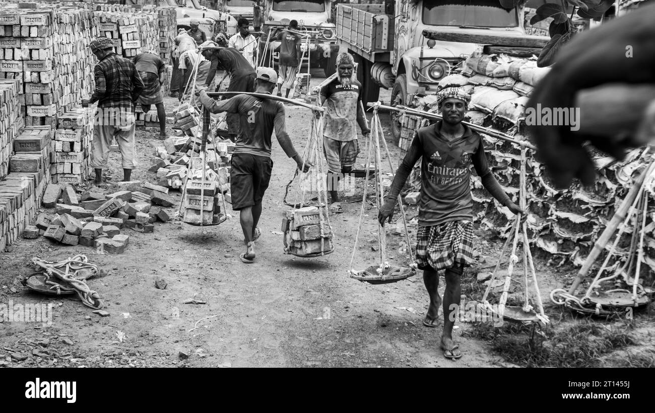 Les gens déchargent des briques du bateau, image capturée le 29 mai 2022, depuis Amen Bazar, au Bangladesh, où les travailleurs sont occupés à décharger des briques lourdes Banque D'Images