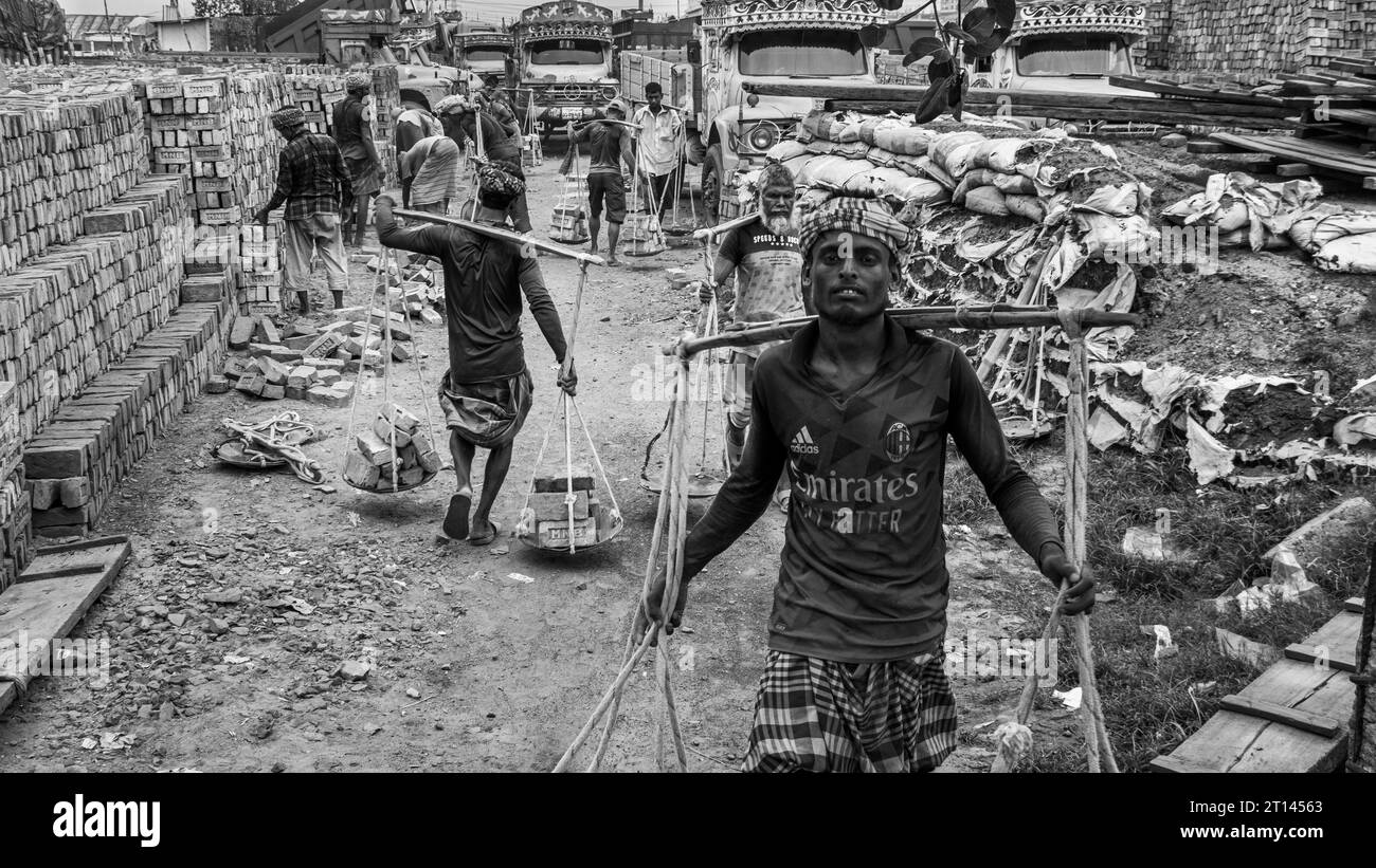 Les gens déchargent des briques du bateau, image capturée le 29 mai 2022, depuis Amen Bazar, au Bangladesh, où les travailleurs sont occupés à décharger des briques lourdes Banque D'Images