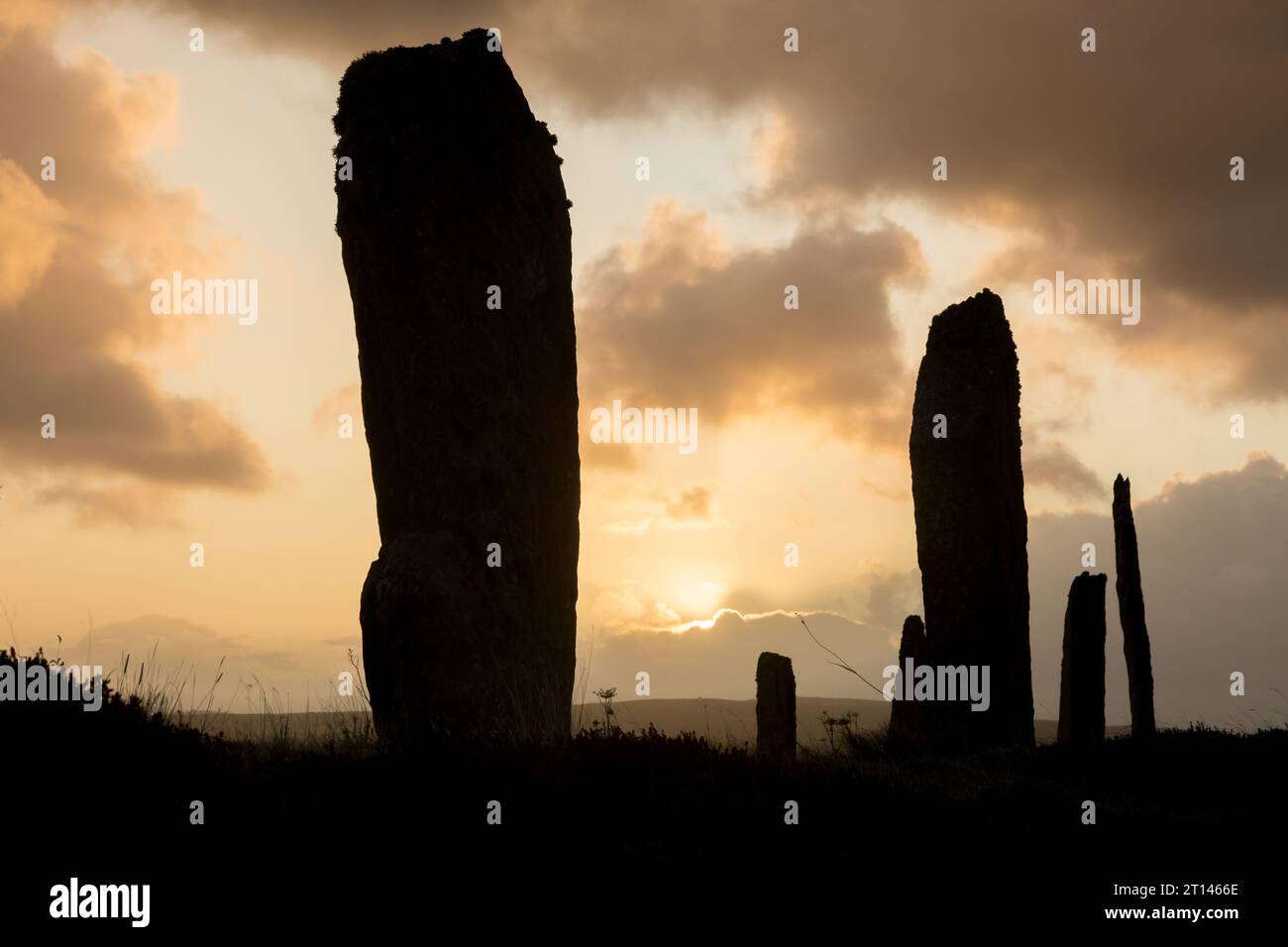 Le soleil se lève derrière les pierres debout néolithiques de l'anneau de Brodgar, Orcades, Royaume-Uni. Banque D'Images