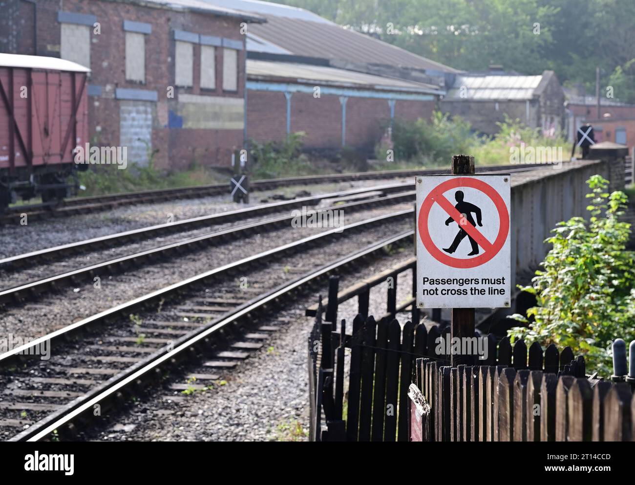 Avis indiquant aux passagers de ne pas traverser la ligne à la gare de Keighley sur le Keighley & Worth Valley Railway. Banque D'Images