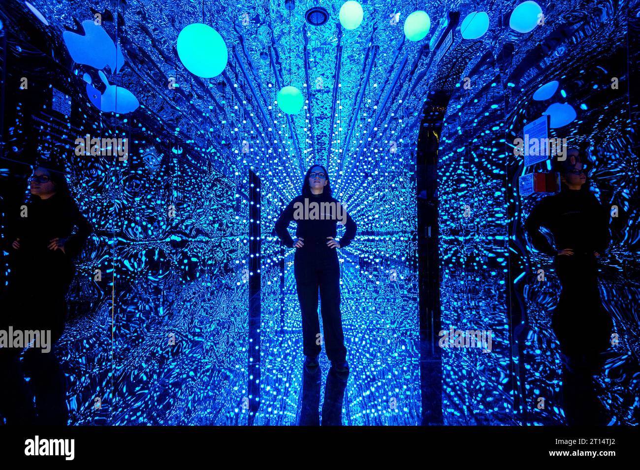 Londres, Royaume-Uni. 11 octobre 2023. Un membre du personnel à l'entrée de l'espace de la galerie avant un aperçu de latent Spaces, une nouvelle exposition immersive chez Illuvisionaries à Crossrail place, Canary Wharf. Le spectacle, de Markos Kay, artiste multidisciplinaire handicapé, qui utilise l’animation et l’intelligence artificielle pour brouiller les frontières entre réalité et illusion, ouvre au public le 14 octobre. Crédit : Stephen Chung / Alamy Live News Banque D'Images