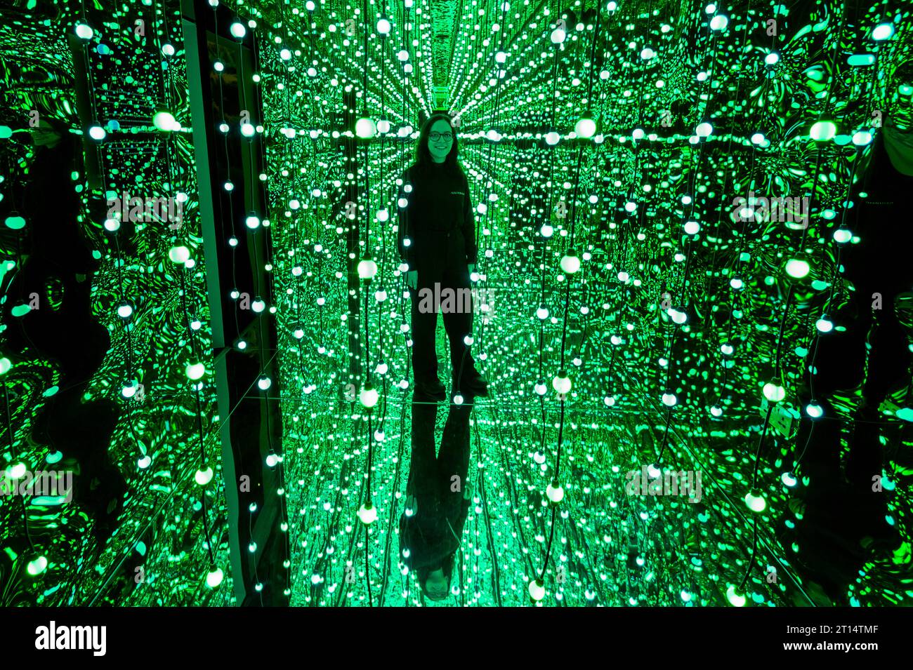 Londres, Royaume-Uni. 11 octobre 2023. Un membre du personnel à l'entrée de l'espace de la galerie avant un aperçu de latent Spaces, une nouvelle exposition immersive chez Illuvisionaries à Crossrail place, Canary Wharf. Le spectacle, de Markos Kay, artiste multidisciplinaire handicapé, qui utilise l’animation et l’intelligence artificielle pour brouiller les frontières entre réalité et illusion, ouvre au public le 14 octobre. Crédit : Stephen Chung / Alamy Live News Banque D'Images