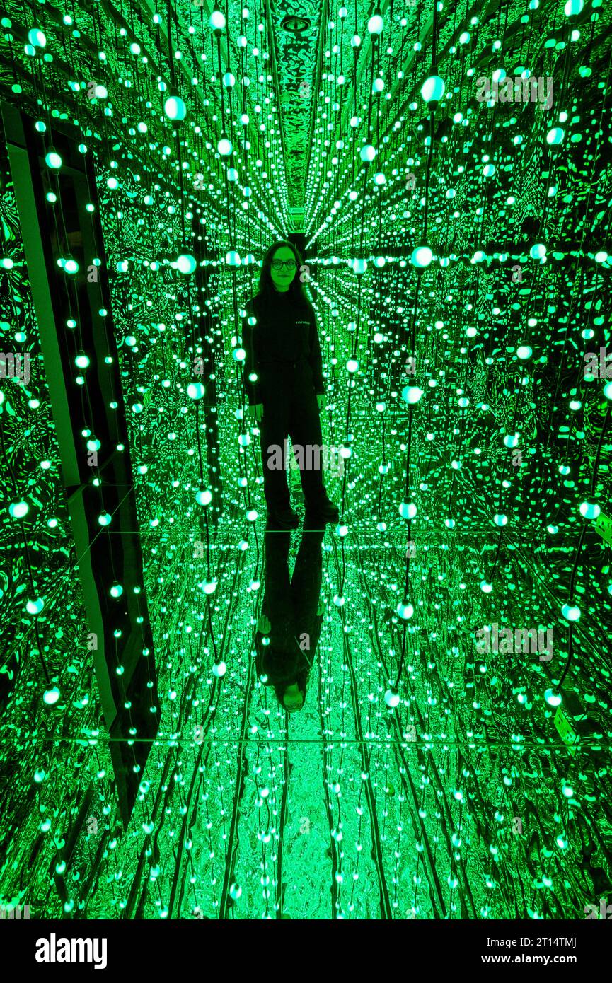 Londres, Royaume-Uni. 11 octobre 2023. Un membre du personnel à l'entrée de l'espace de la galerie avant un aperçu de latent Spaces, une nouvelle exposition immersive chez Illuvisionaries à Crossrail place, Canary Wharf. Le spectacle, de Markos Kay, artiste multidisciplinaire handicapé, qui utilise l’animation et l’intelligence artificielle pour brouiller les frontières entre réalité et illusion, ouvre au public le 14 octobre. Crédit : Stephen Chung / Alamy Live News Banque D'Images