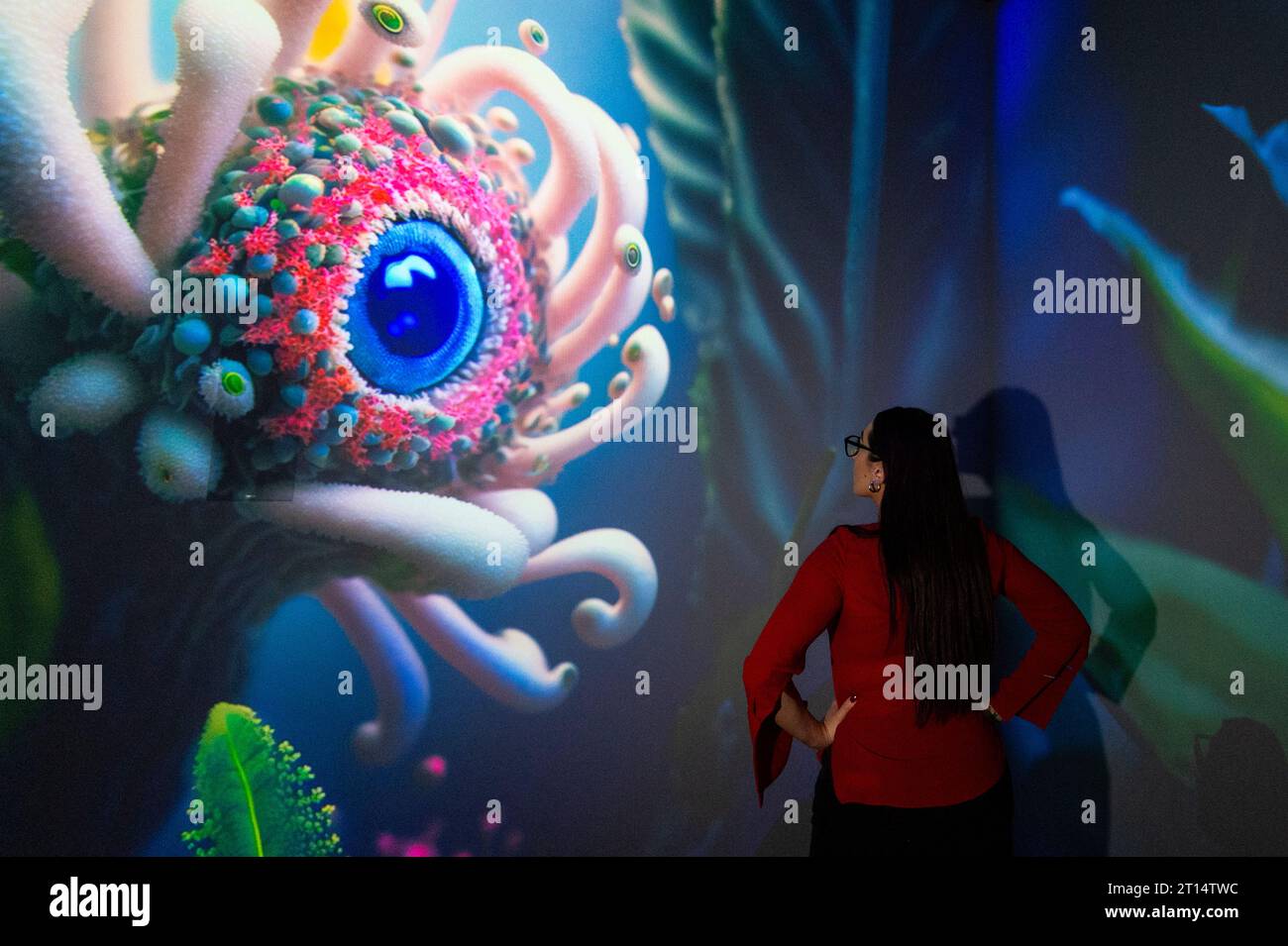 Londres, Royaume-Uni. 11 octobre 2023. Un membre du personnel de Complexity Space, qui fait partie de latent Spaces, une nouvelle exposition immersive présentée en avant-première à Illuvisionaries à Crossrail place, Canary Wharf. Le spectacle, de Markos Kay, artiste multidisciplinaire handicapé, qui utilise l’animation et l’intelligence artificielle pour brouiller les frontières entre réalité et illusion, ouvre au public le 14 octobre. Crédit : Stephen Chung / Alamy Live News Banque D'Images
