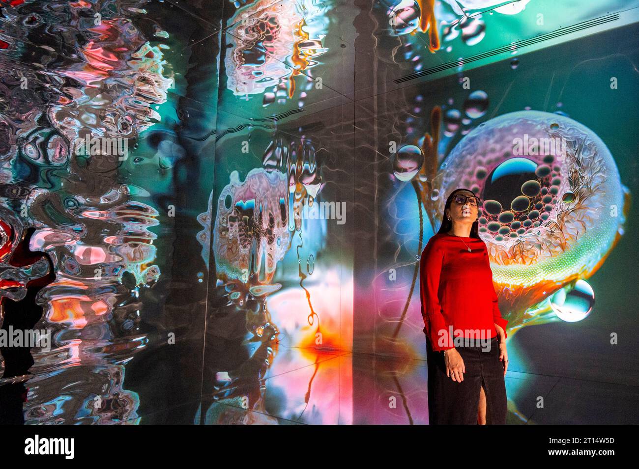 Londres, Royaume-Uni. 11 octobre 2023. Un membre du personnel de formations Space, qui fait partie de latent Spaces, une nouvelle exposition immersive présentée en avant-première à Illuvisionaries à Crossrail place, Canary Wharf. Le spectacle, de Markos Kay, artiste multidisciplinaire handicapé, qui utilise l’animation et l’intelligence artificielle pour brouiller les frontières entre réalité et illusion, ouvre au public le 14 octobre. Crédit : Stephen Chung / Alamy Live News Banque D'Images