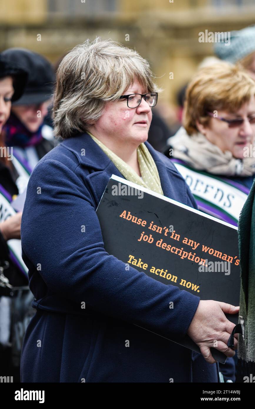 Thérèse Coffey députée lors de la manifestation pour l'égalité des femmes de mars 4 organisée par Care International à Londres, Royaume-Uni. Slogan abus contre la femme Banque D'Images