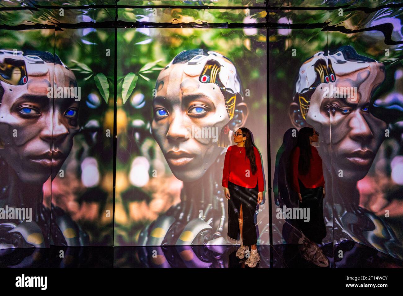 Londres, Royaume-Uni. 11 octobre 2023. Un membre du personnel de agents Space, qui fait partie de latent Spaces, une nouvelle exposition immersive présentée en avant-première à Illuvisionaries à Crossrail place, Canary Wharf. Le spectacle, de Markos Kay, artiste multidisciplinaire handicapé, qui utilise l’animation et l’intelligence artificielle pour brouiller les frontières entre réalité et illusion, ouvre au public le 14 octobre. Crédit : Stephen Chung / Alamy Live News Banque D'Images