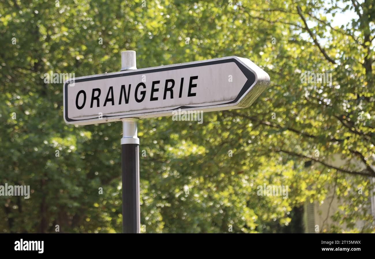 Panneau avec texte ORANGERIE signifiant ORANGERIE en langue française dans le parc public avec des arbres adverbes Banque D'Images