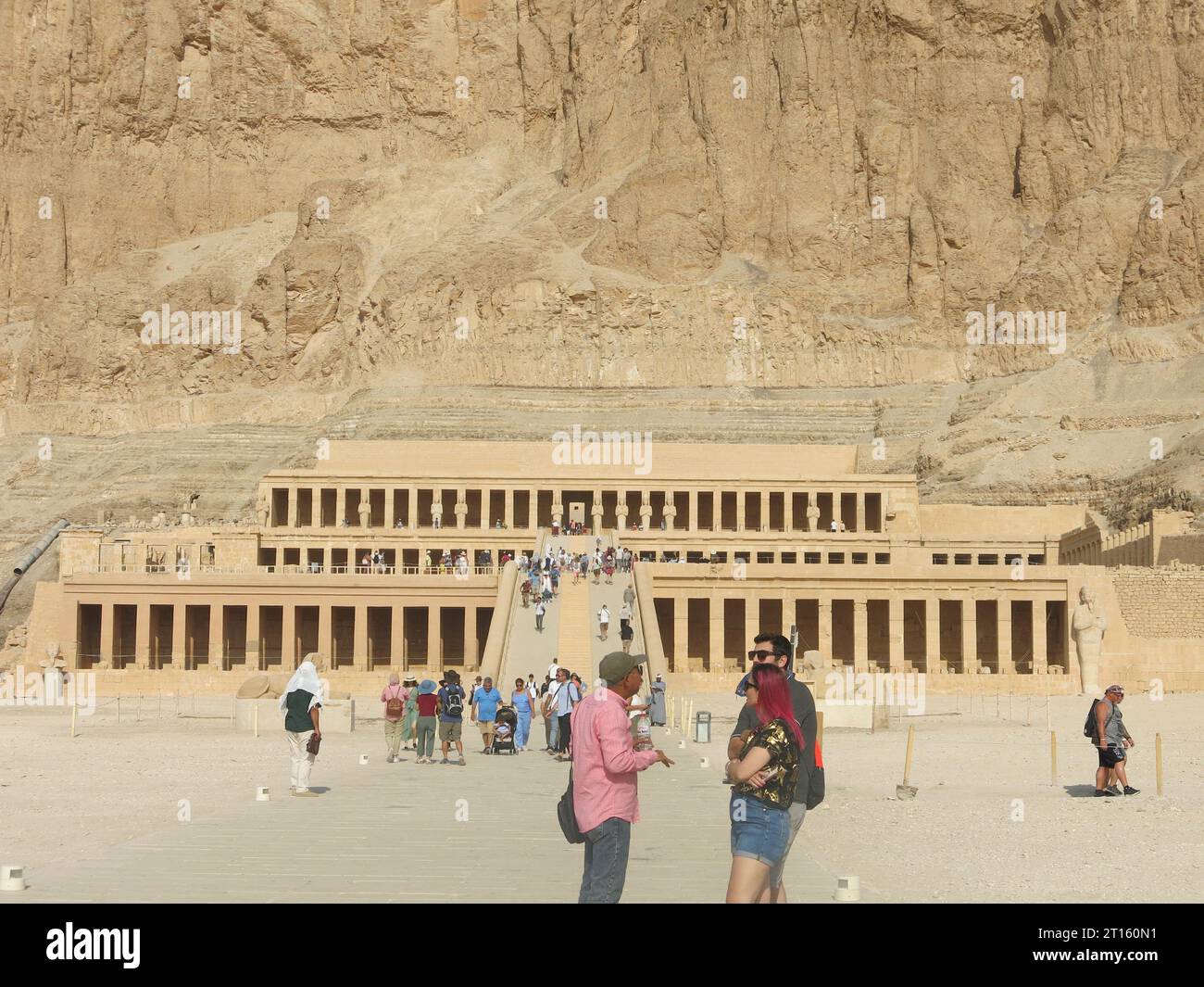 Les touristes affluent pour voir le magnifique temple mortuaire de Hatshepsut, construit dans les falaises, un chef-d'œuvre de l'architecture de l'Egypte ancienne. Banque D'Images