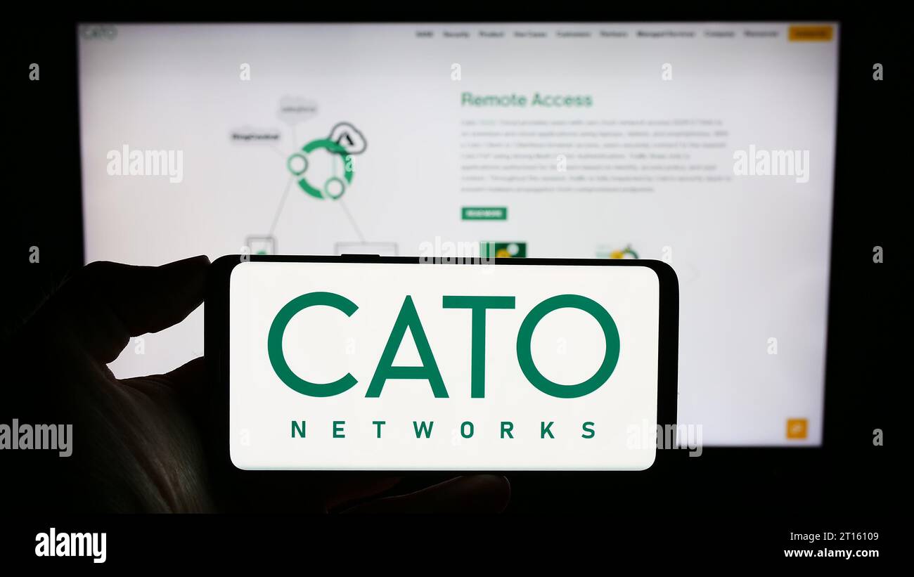 Personne tenant un téléphone portable avec le logo de la société israélienne de sécurité réseau Cato Networks Ltd. Devant la page Web de l'entreprise. Concentrez-vous sur l'affichage du téléphone. Banque D'Images