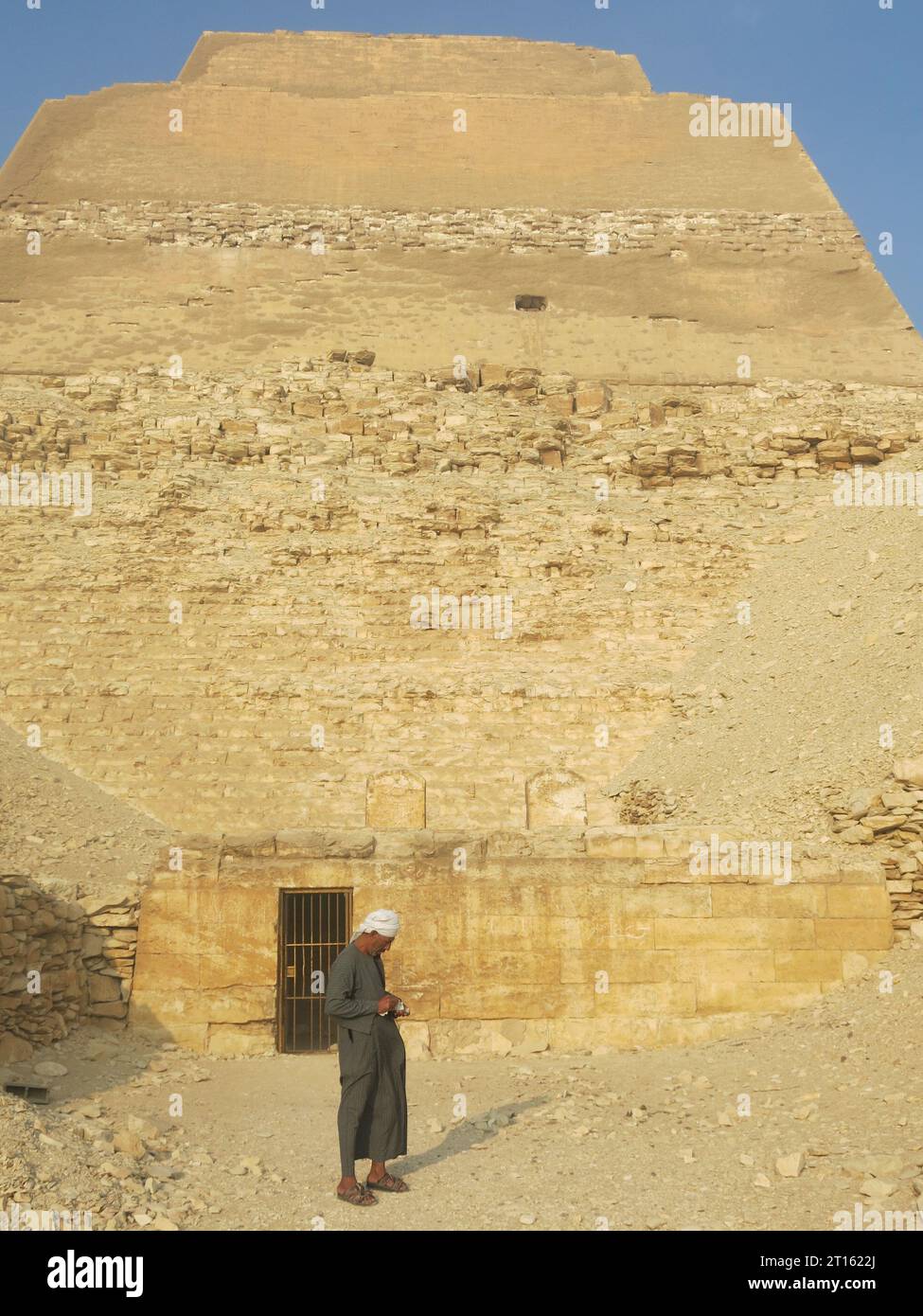 Homme en robe égyptienne (gallibaya) à l'extérieur de la pyramide Meidum de 70m de haut, Basse-Égypte. Banque D'Images