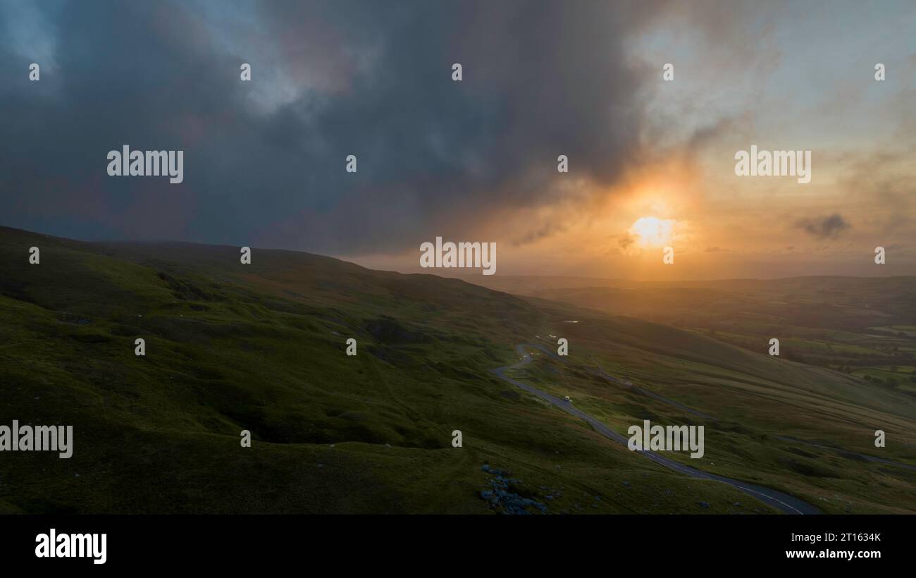 Un coucher de soleil brumeux sur la montagne Noire dans le Carmarthenshire, pays de Galles du Sud Royaume-Uni Banque D'Images