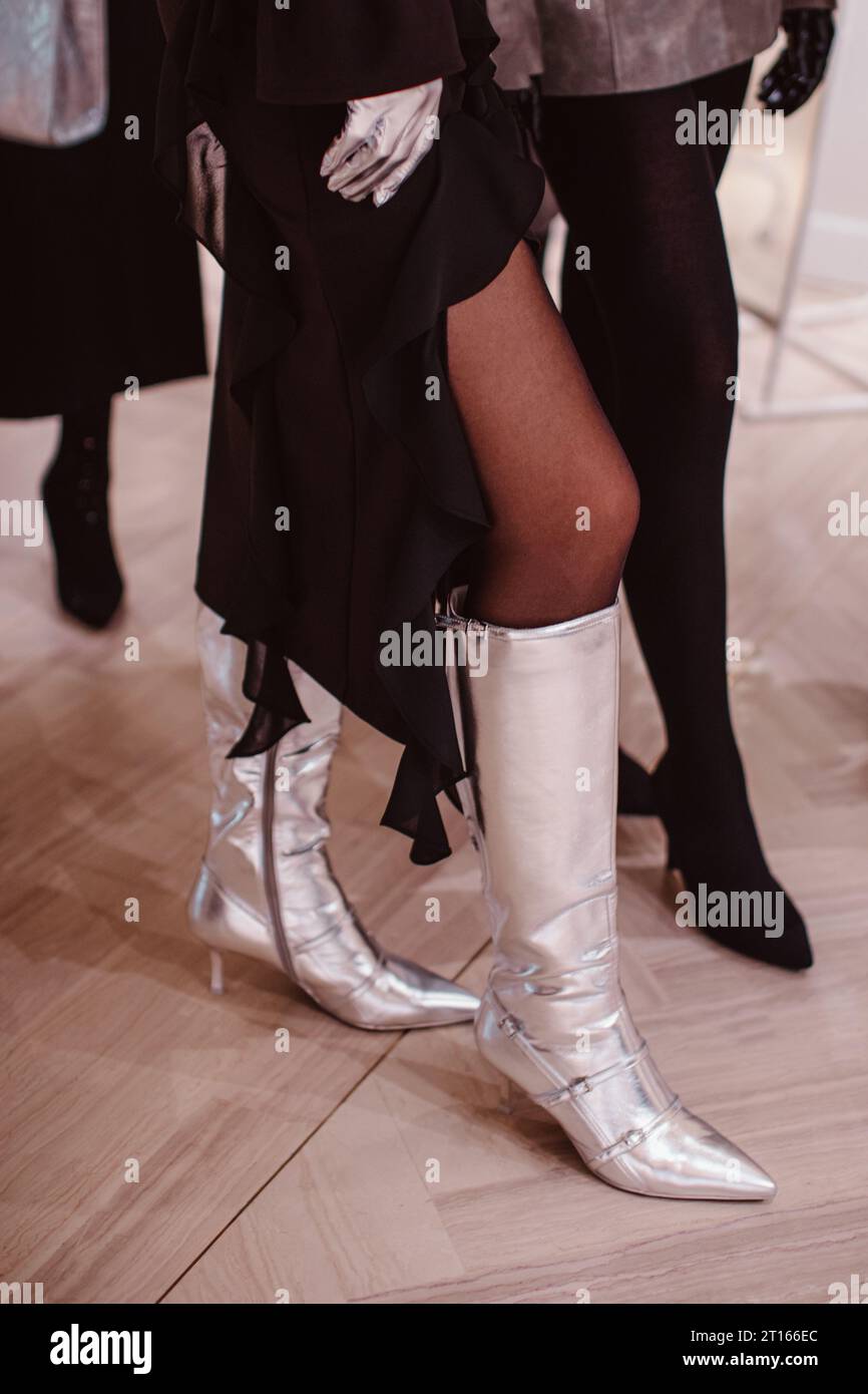 Mannequin sur les coulisses habillé d'une jupe longue noire et de talons hauts argentés. Préparation avant le défilé de mode Banque D'Images