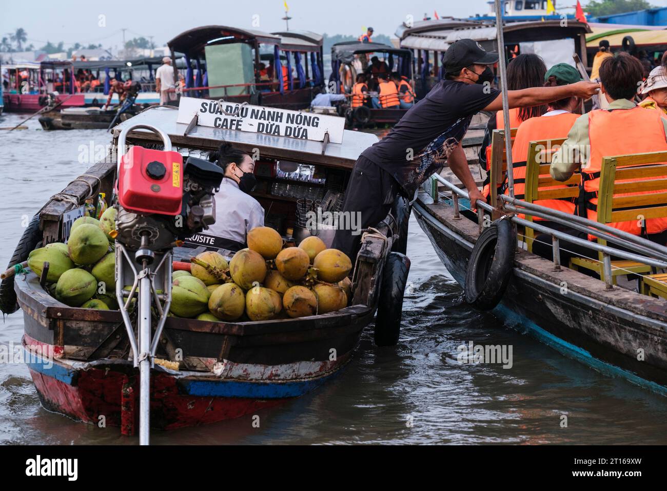 Scène du marché flottant de Phong Dien, près de CAN Tho, Vietnam. Vendeur vendant des noix de coco à Tourist Boat. Banque D'Images