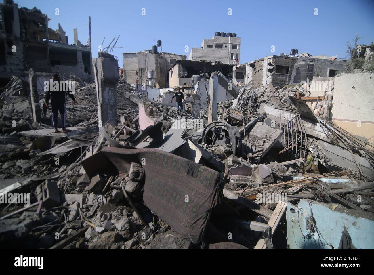 Gaza. 11 octobre 2023. Les gens inspectent les bâtiments détruits lors des frappes aériennes israéliennes dans la ville de Rafah, dans le sud de la bande de Gaza, le 11 octobre 2023. Le mouvement de résistance islamique palestinien (Hamas) a lancé samedi une attaque surprise contre des villes israéliennes adjacentes à la bande de Gaza, incitant Israël à lancer des frappes de représailles sur Gaza. Mercredi, plus de 2 000 personnes ont été tuées et des milliers d'autres blessées des deux côtés. Crédit : Khaled Omar/Xinhua/Alamy Live News Banque D'Images