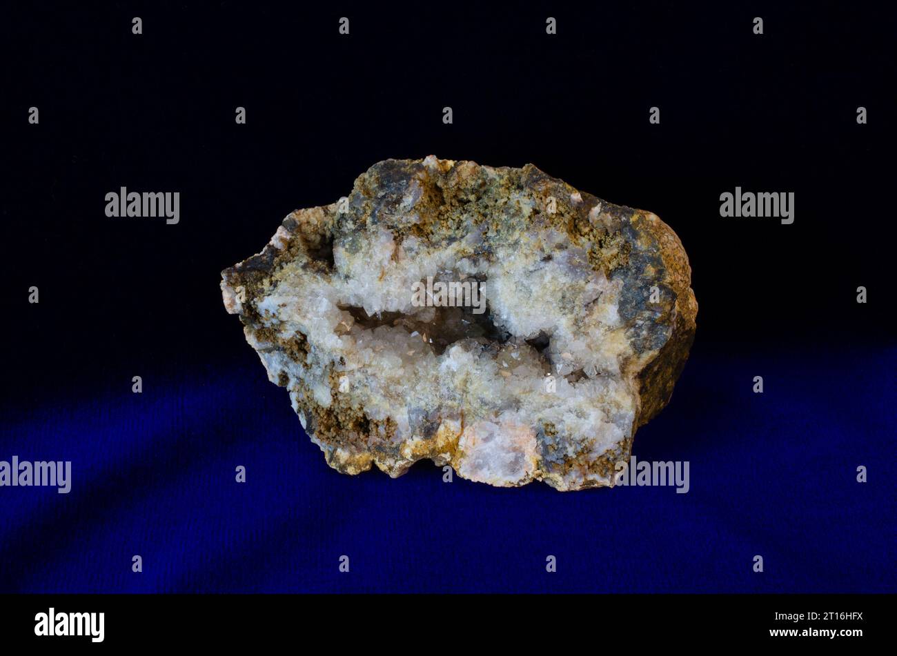 Croissance cristalline à l'intérieur de roche minérale brute. Belle gemme géologique naturelle déterrée et fissurée ouverte pour révéler un amas de cristaux. Banque D'Images