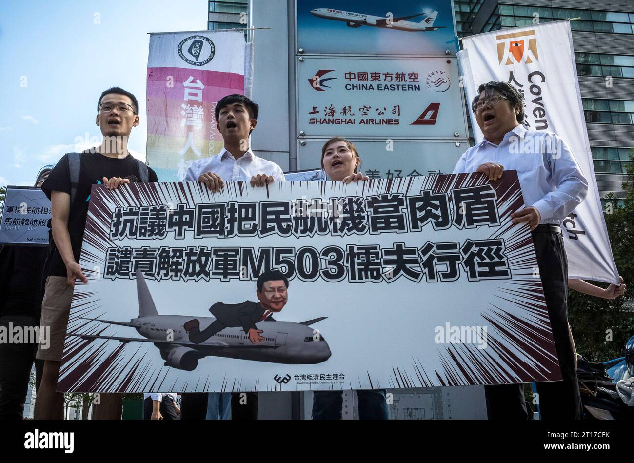 Taipei, Taiwan le 12/10/2023. Des manifestants de l'"Union de la démocratie économique de Taiwan" manifestent devant les bureaux de "China Eastern Airlines" à Taipei, Taiwan, le 12/10/2023. Ils tiennent une affiche montrant une caricature de Xi Jinping, le leader chinois, à bord d'un avion. La manifestation est en réponse aux actions de l'armée chinoise, qui a délibérément utilisé les vols commerciaux de 'Cathay Pacific' comme couverture le long de la route M503, conduisant à la confusion pour les forces aériennes taïwanaises. La décision de l'armée chinoise viole une promesse de ne pas utiliser cette route à des fins militaires, et les manifestants le sont Banque D'Images