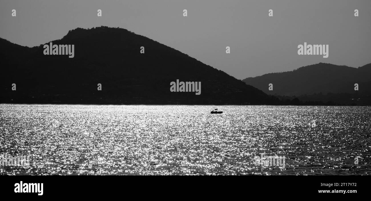 Un pêcheur solitaire sur son bateau sur le lac Iseo Lombardie Italie. Septembre 2023 Banque D'Images