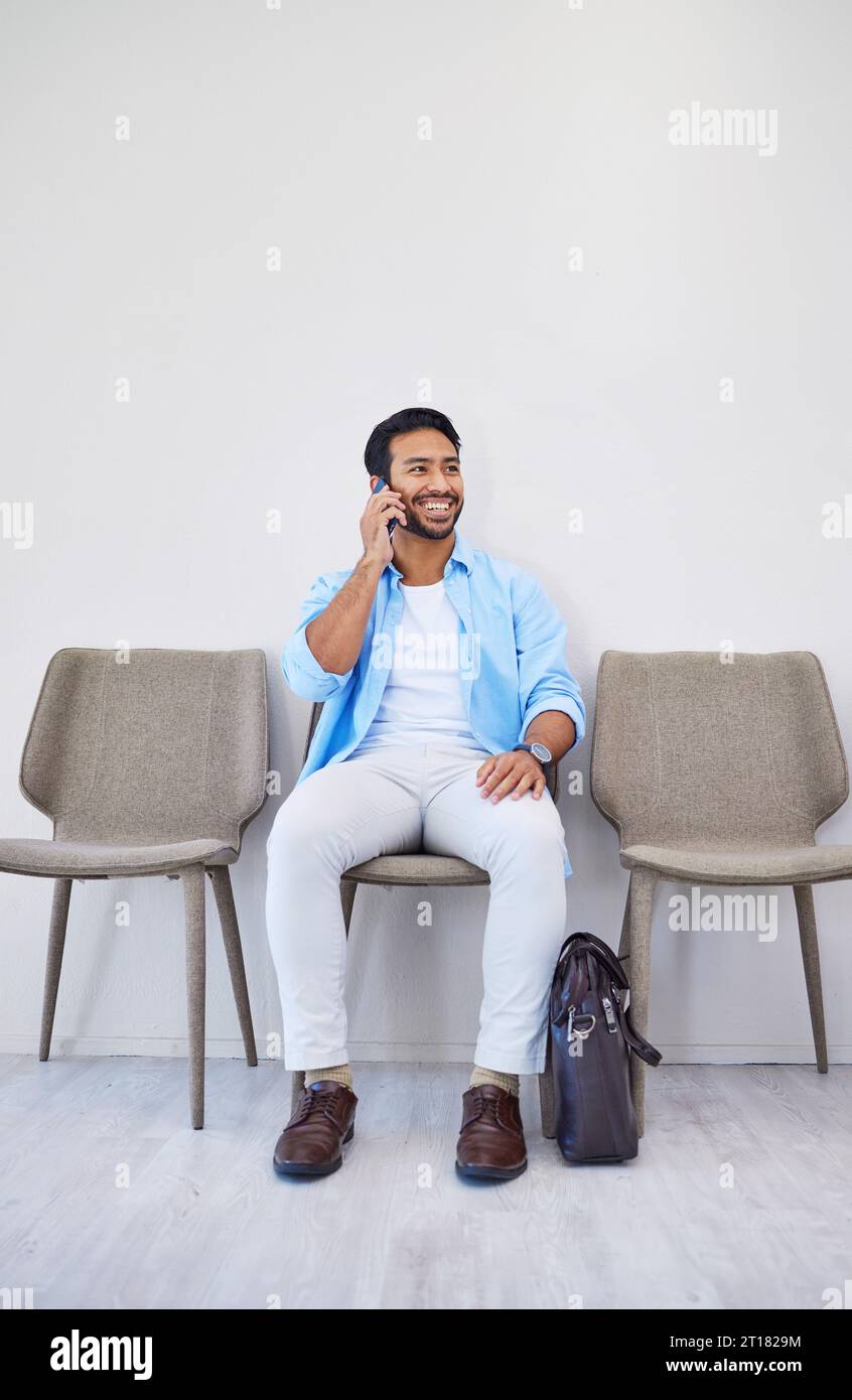 Salle d'attente, appel téléphonique et homme dans un bureau pour une entrevue dans la recherche d'emploi pour rendez-vous. Embauche, carrière et personne masculine indienne sur mobile Banque D'Images