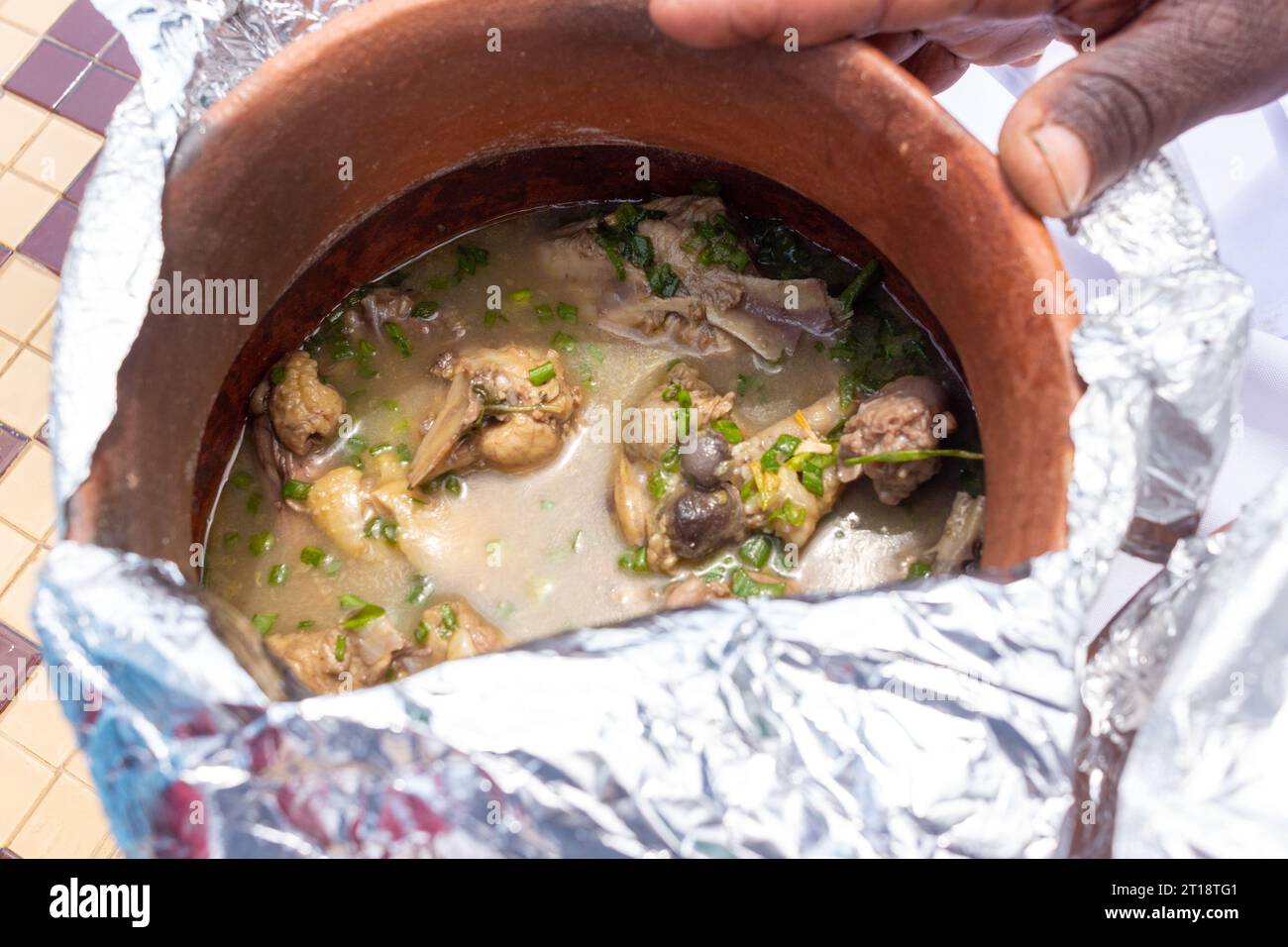 Version mozambicaine africaine de poulet Cafreal cuit dans un pot d'argile avec des poulets fermiers locaux Banque D'Images