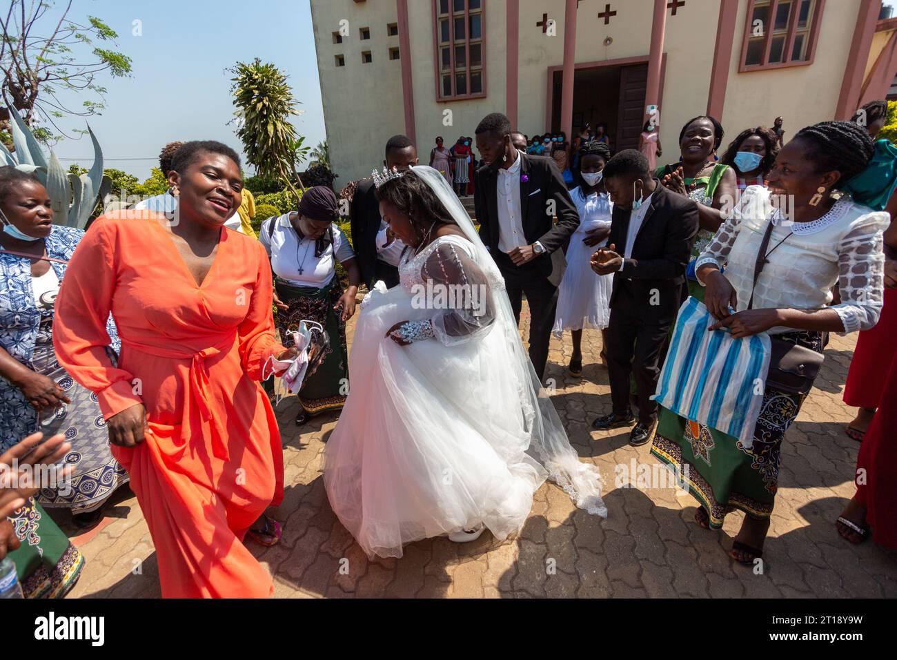 Manica, Mozambique - 09 octobre 2021 : Happy bride dansant avec des invités à l'extérieur de l'église après le mariage Banque D'Images