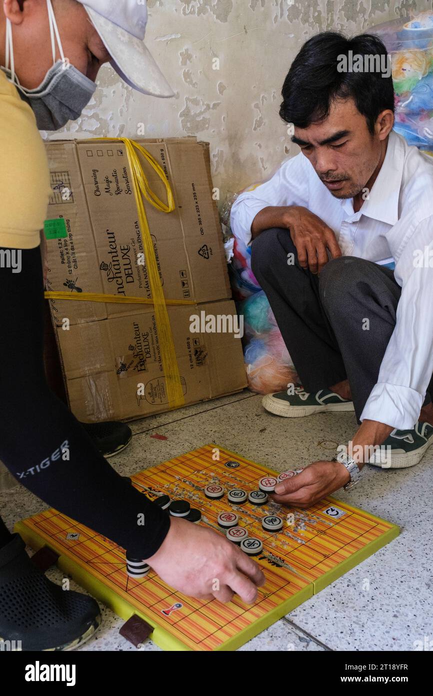 Hommes jouant aux échecs chinois, Co Vay, scène de marché Binh Tay, Ho Chi Minh ville, Vietnam. Banque D'Images