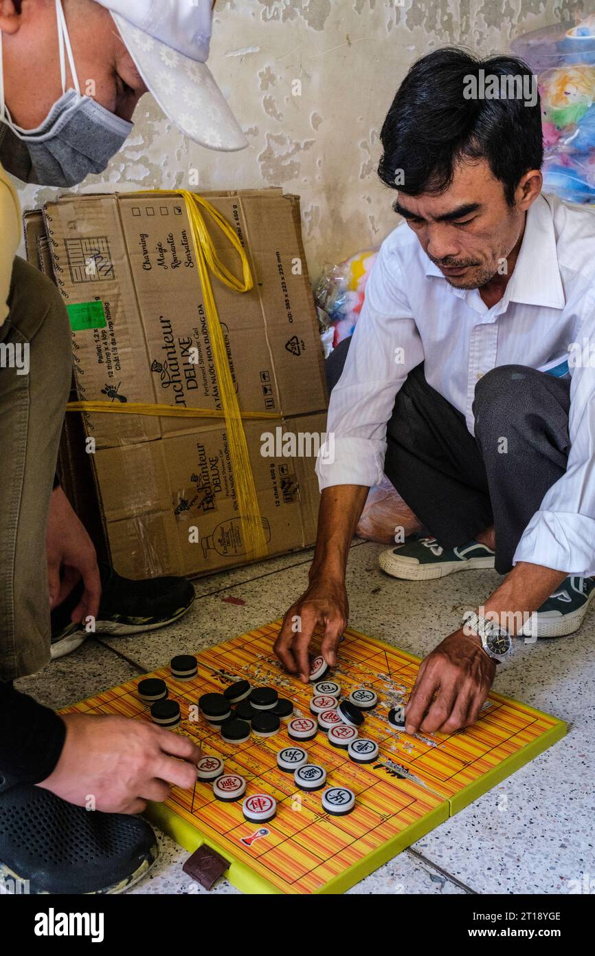 Hommes jouant aux échecs chinois, Co Vay, scène de marché Binh Tay, Ho Chi Minh ville, Vietnam. Banque D'Images