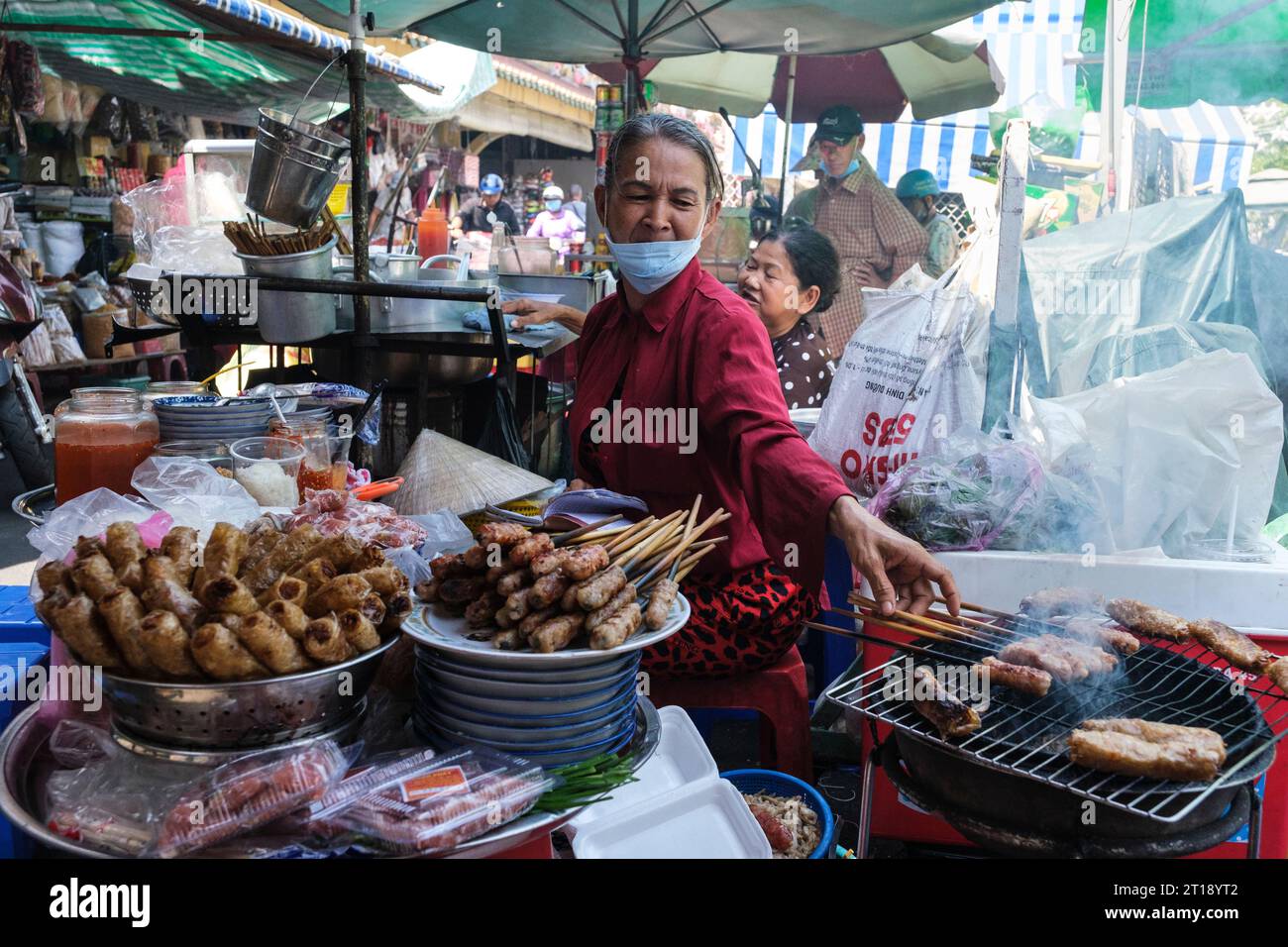 Binh Tay Market Scene, Vendor Roasting Meat over Charcoal, Ho Chi Minh ville, Vietnam. Banque D'Images