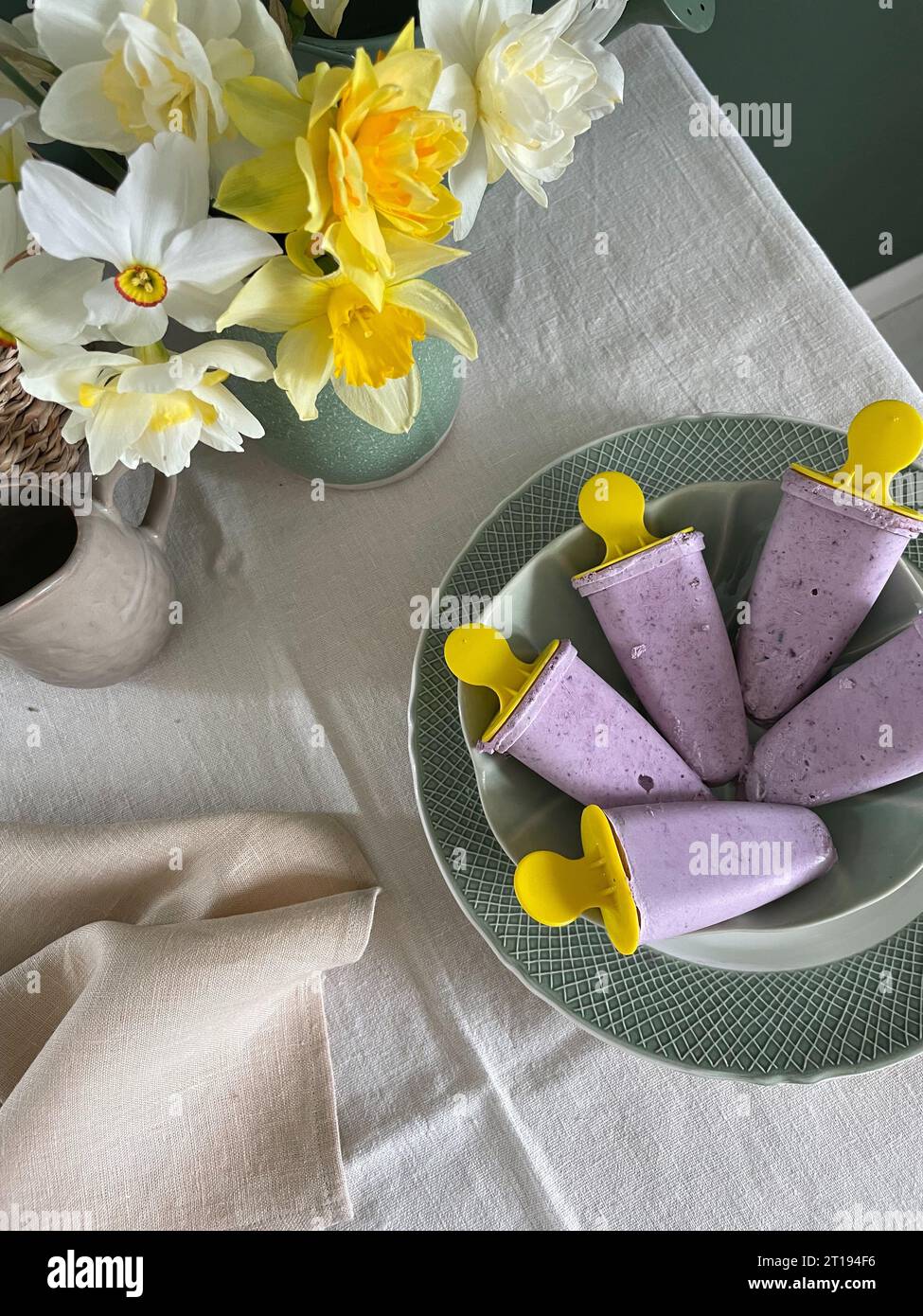 Crème glacée aux myrtilles sans sucre maison dans un bol à côté d'un bouquet de fleurs Banque D'Images