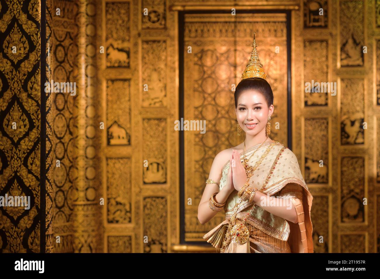 Femme souriante debout avec ses mains en position de prière, Thaïlande Banque D'Images