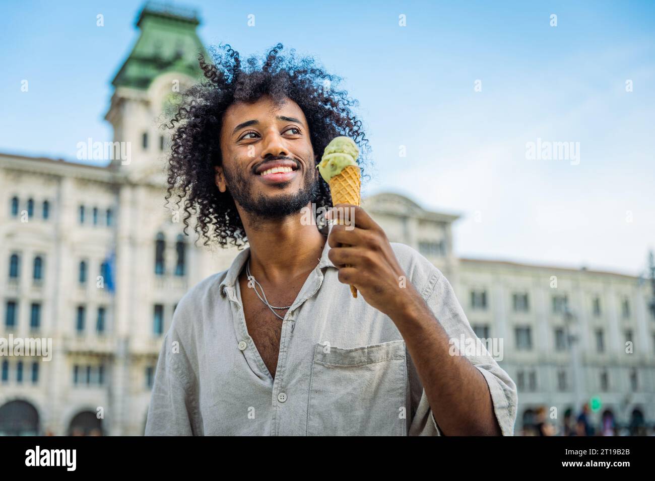 Un jeune homme mange de la crème glacée tout en profitant de ses vacances à Trieste Banque D'Images