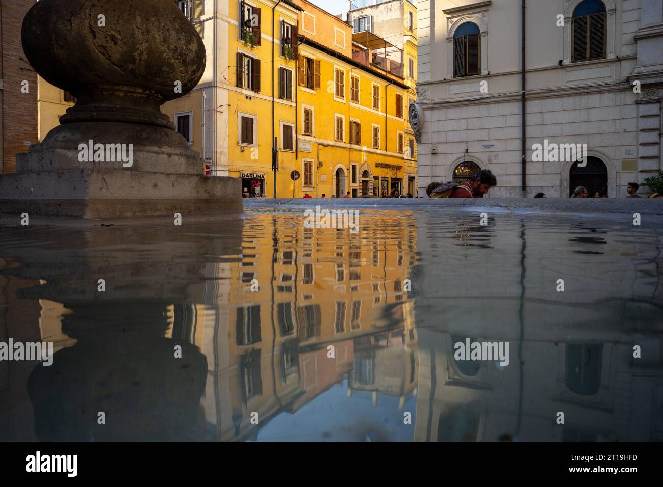 Place typique de Rome avec maison jaune et fontaine en pierre. Banque D'Images
