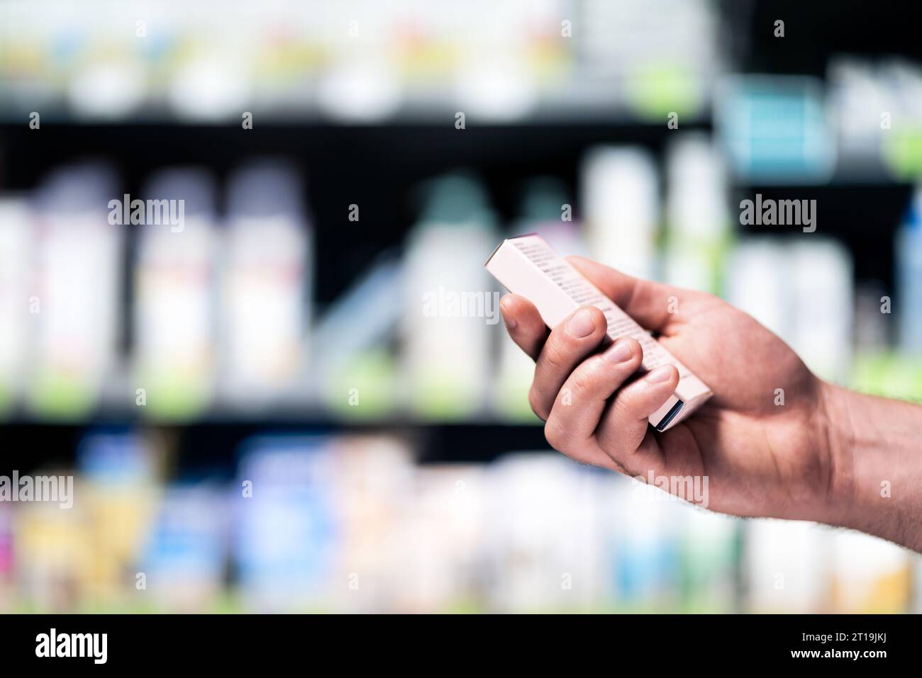 Boîte à médicaments dans la pharmacie ou la pharmacie. Client avec le produit médical dans le supermarché ou le magasin de drogue. Homme avec des vitamines ou du zinc à la main. Banque D'Images