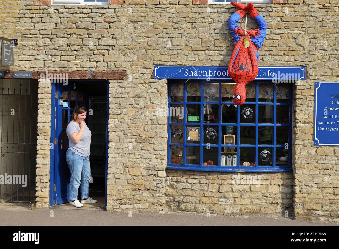 Spider-man épouvantail devant Deli Cafe pendant le festival du village épouvantail à Sharnbrook High Street, Bedfordshire, Angleterre, Royaume-Uni Banque D'Images