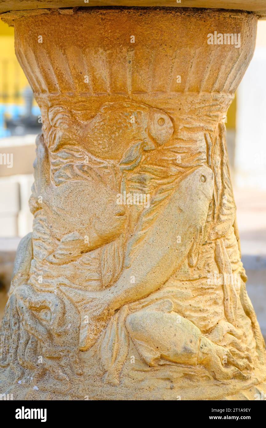 Fontaine médiévale en pierre dans une petite place. L'objet ancien a été récemment restauré et il montre des décorations en bas relief. Banque D'Images